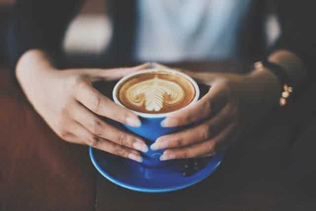 tazza di caffè tenuta in mano